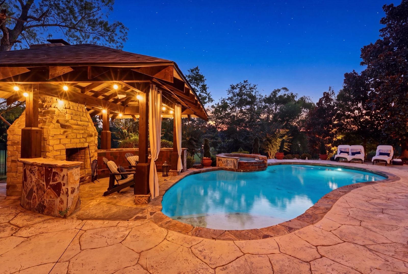 Outdoor living area with pool at dusk