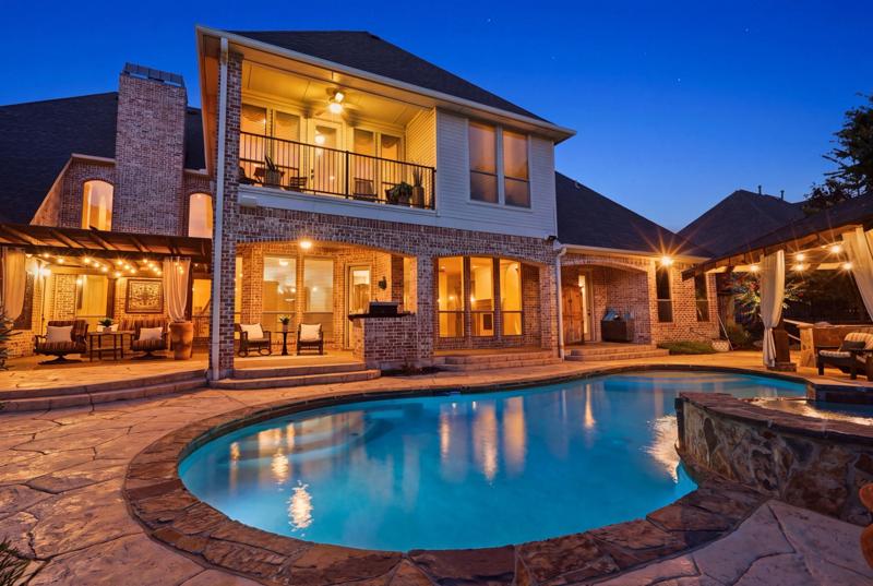 Twilight photo of a home with pool